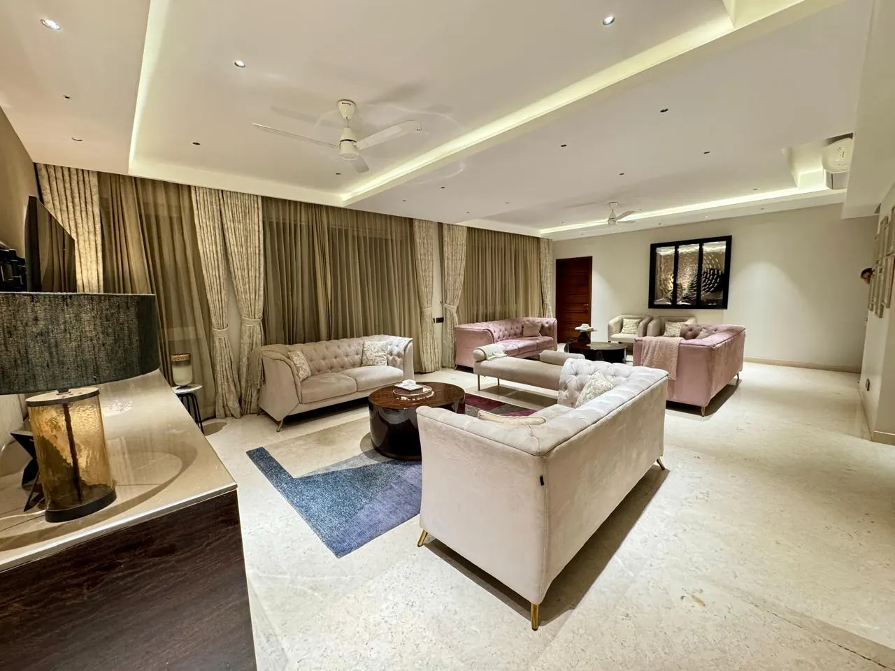 An elegant, softly lit living room with plush sofas in a premium Hebbal residence