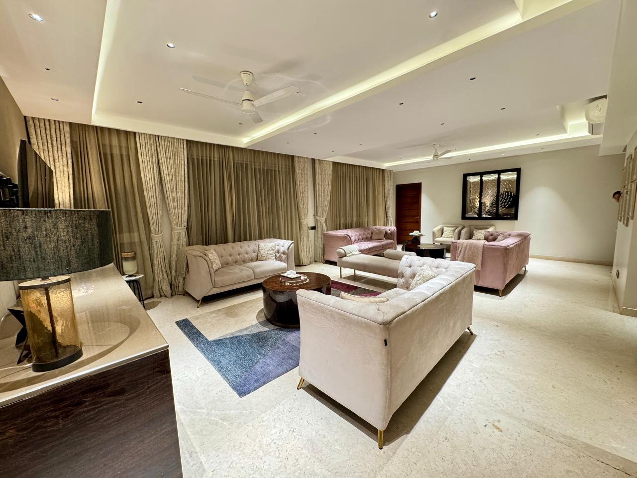 An elegant, softly lit living room with plush sofas in a premium Hebbal residence