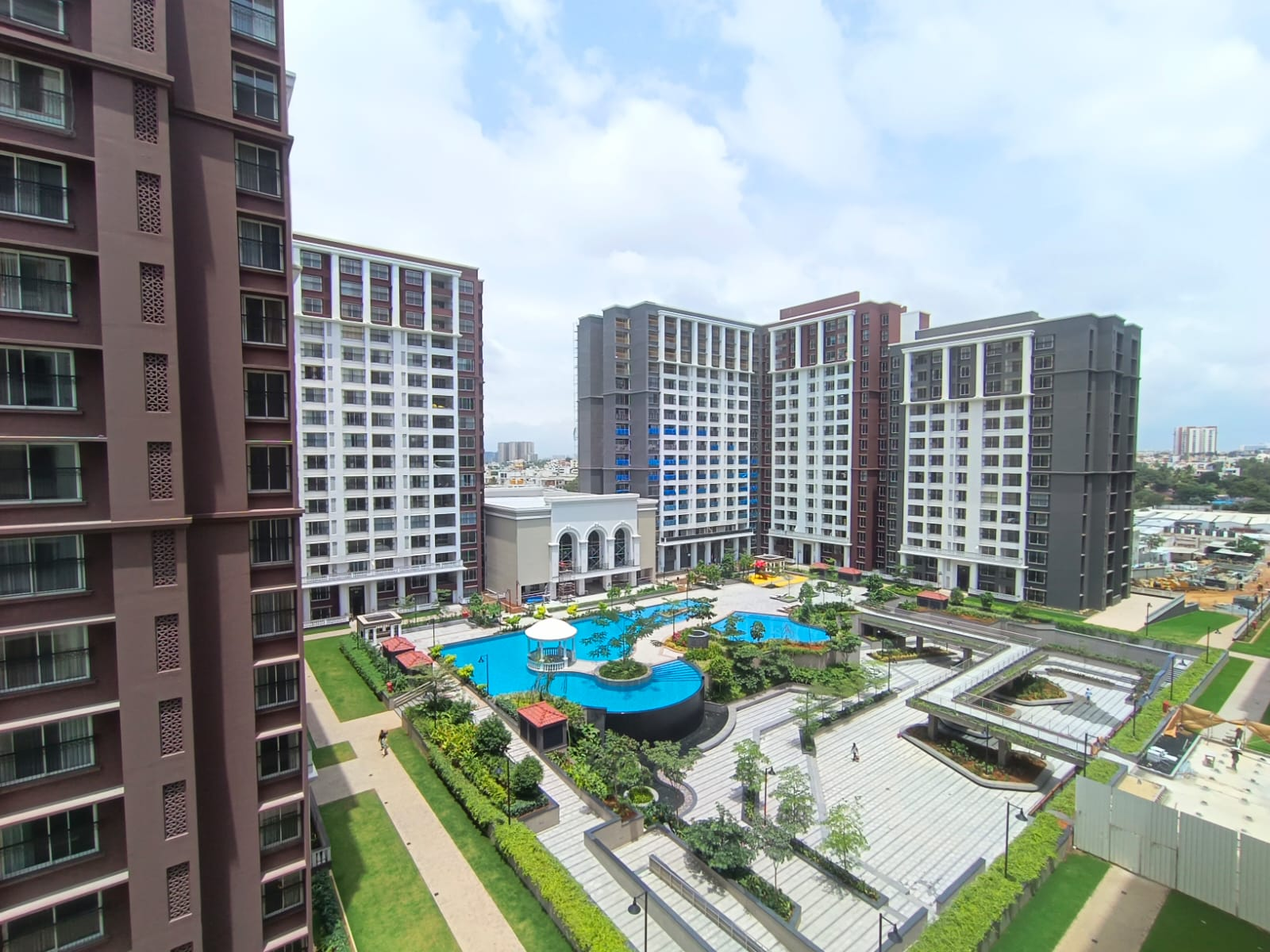 Residential towers overlooking a landscaped pool and green courtyard at Embassy Lake Terraces, Hebbal